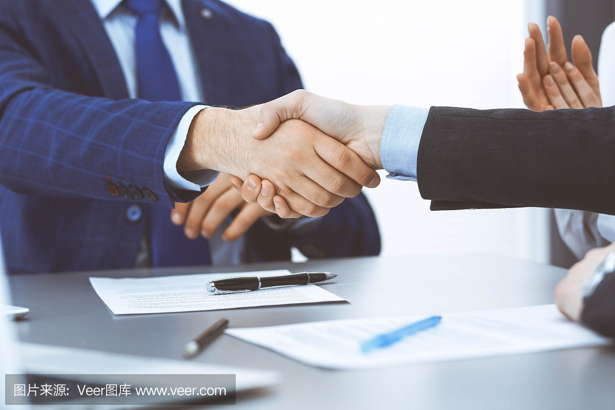 商人們握手,完成一份文件簽名。會(huì)議、合同及律師咨詢(xún)理念